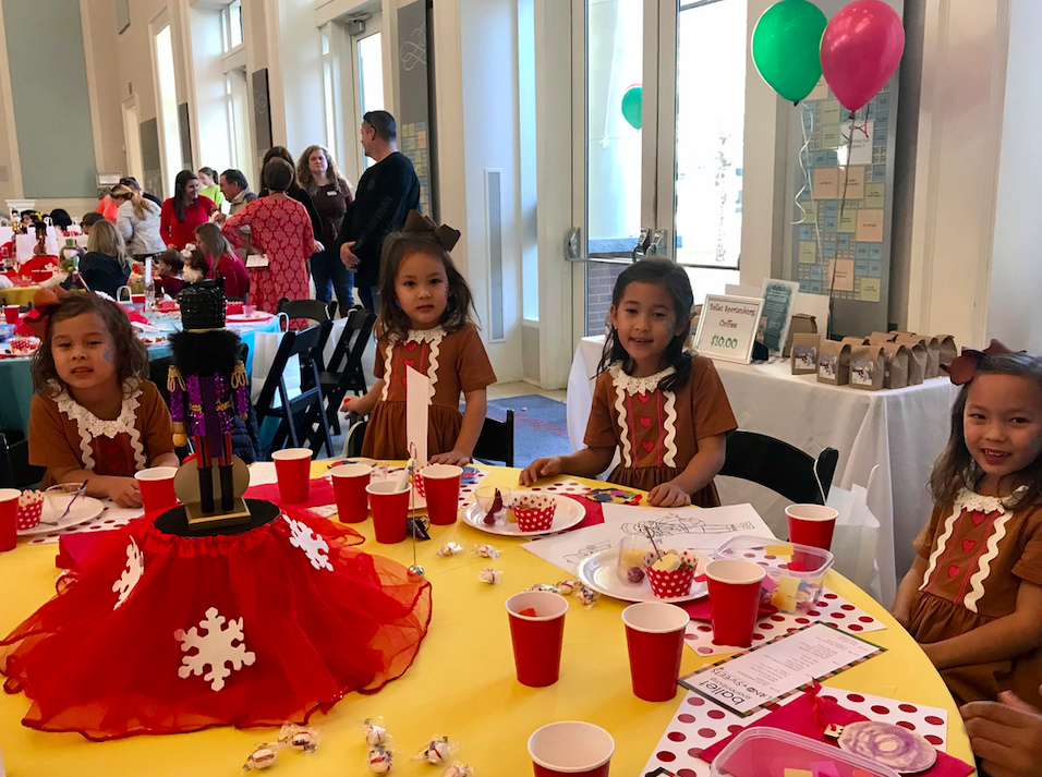 Children eating sweets at a table. 