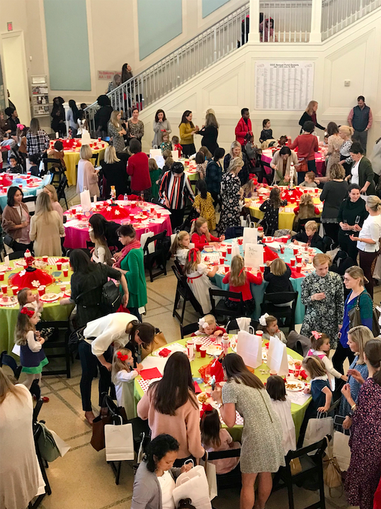 Crowded floor filled with people, chairs, and tables. 