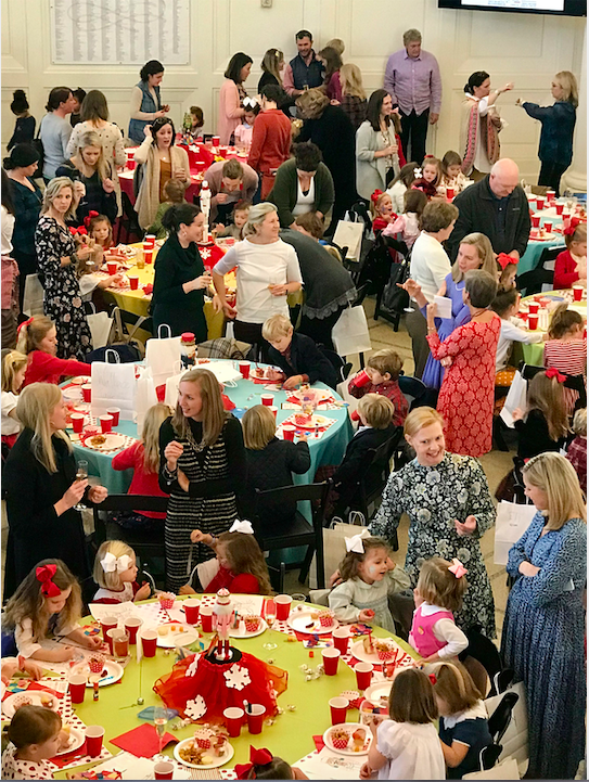 Crowded floor filled with people, chairs, and tables. 